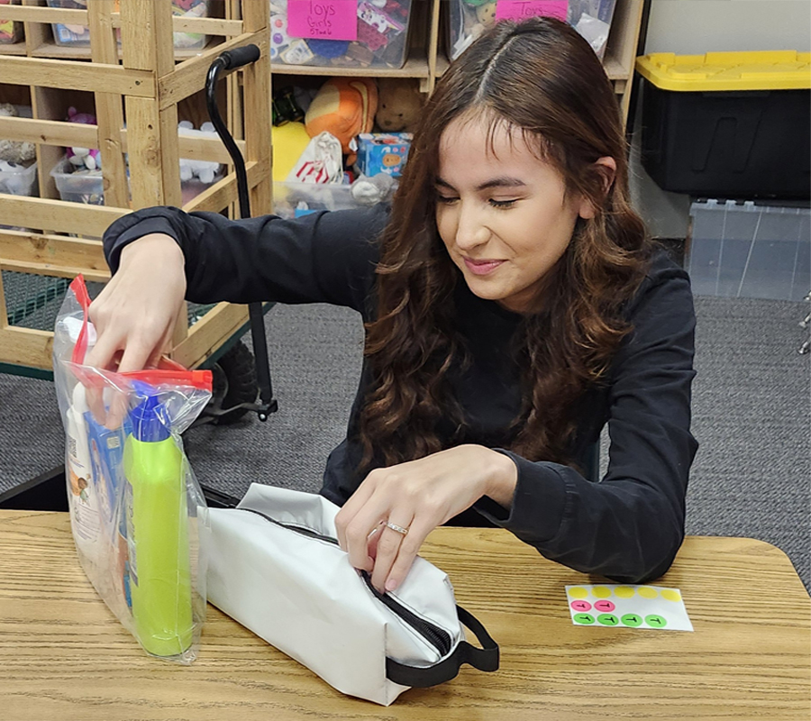 girl filling backpack with toileteries